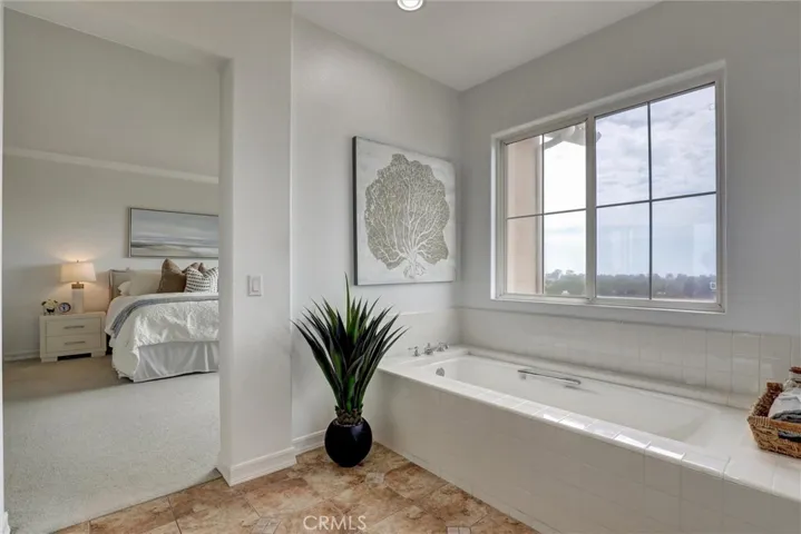 Even the primary bathroom enjoys breathtaking panoramic views of the Upper Newport Bay, Newport Harbor, and the Pacific Ocean beyond, creating a truly extraordinary retreat.