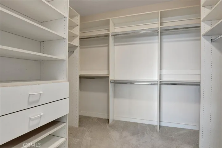 A thoughtfully designed walk-in closet features extensive built-in storage and organization.