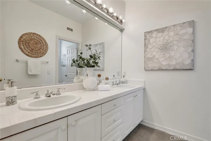 Dual vanities and generous counter space enhance the spacious secondary bathroom.