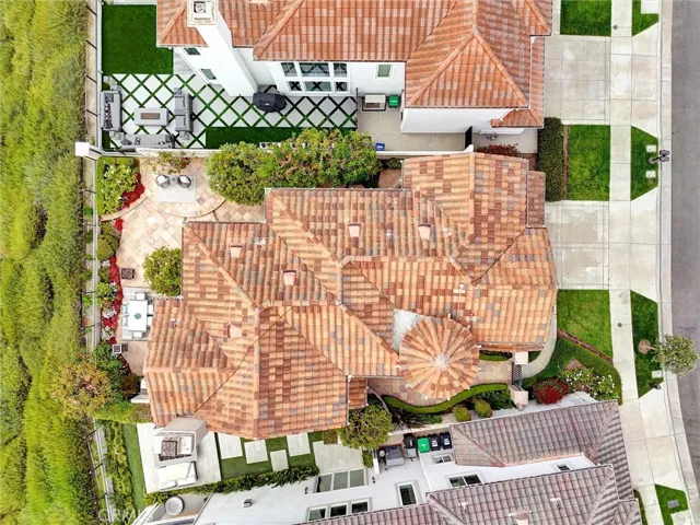 An overhead perspective showcases the home's distinctive rooflines, turret, and thoughtfully designed outdoor living spaces.