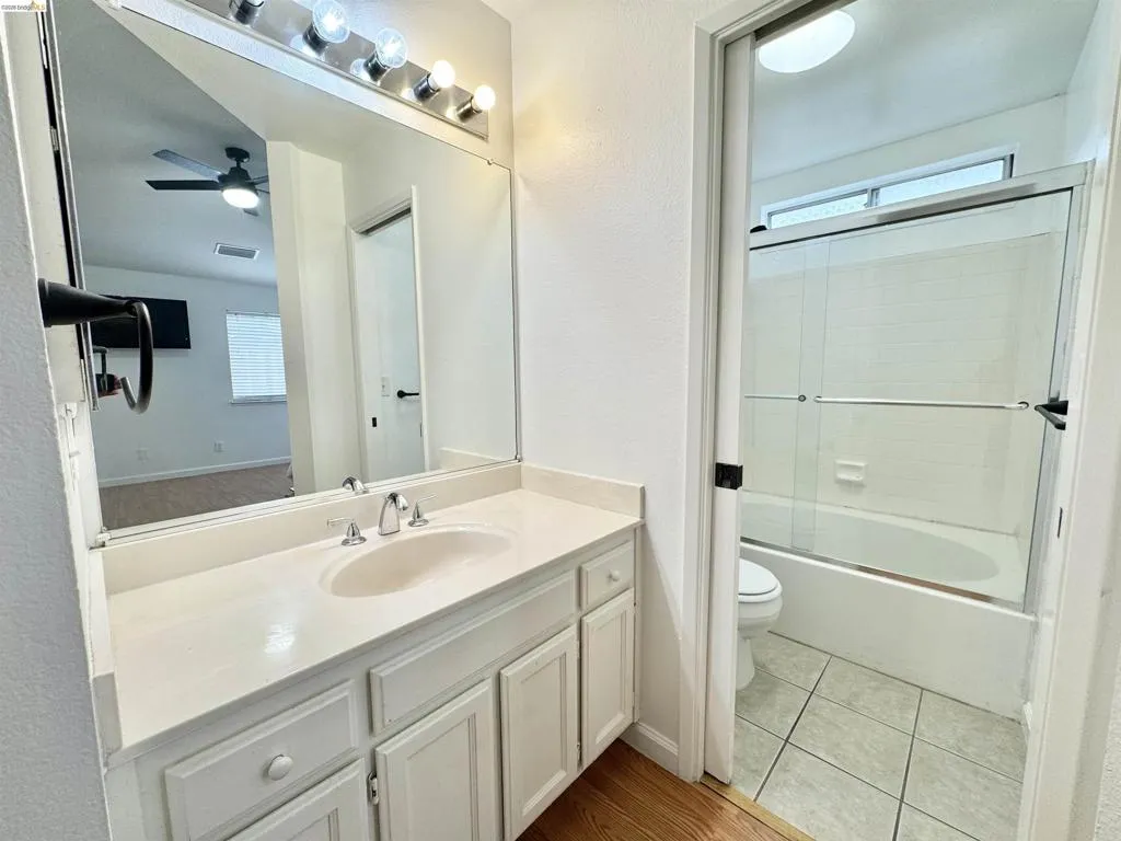 Bathroom featuring a large vanity with an integrated sink, polished chrome faucet, and storage cabinetry