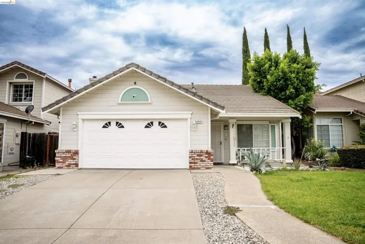Single-story residence featuring a two-car garage, brick façade accents, and a covered entry porch