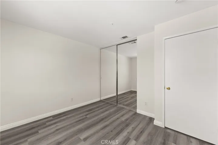 Guest room with new paint, new flooring, and mirrored closet doors.