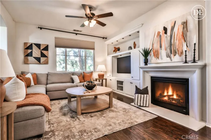 Lake view living room with cozy fireplace, new ceiling fan, hardwood and more