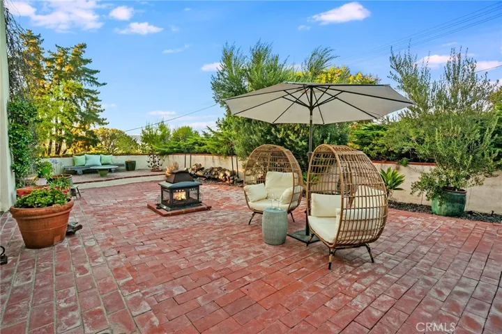 Privacy continues throughout the backyard, where mature trees that include avocado and orange trees, and established landscaping surround the pool and create a setting that feels peaceful without sacrificing usable outdoor space. Multiple patios, gardens, artificial turf, a fire pit, a clawfoot bathtub, and a dedicated cold plunge create inviting spaces to relax, entertain, or simply enjoy the privacy that surrounds you.