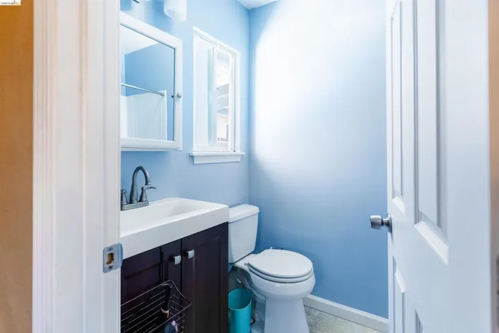 Bathroom featuring a dark wood-finish vanity with a rectangular basin, brushed nickel faucet, and a mirrored medicine cabinet