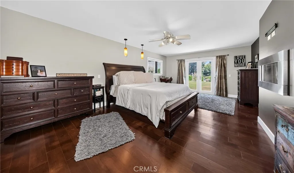 Large primary bedroom with beautiful hardwood floors. French doors open to backyard.