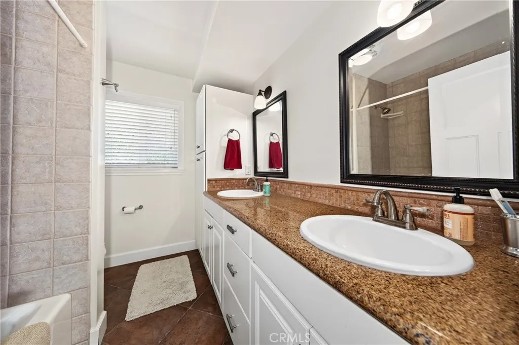 Hall bathroom with double sinks, granite and shower/tub combo