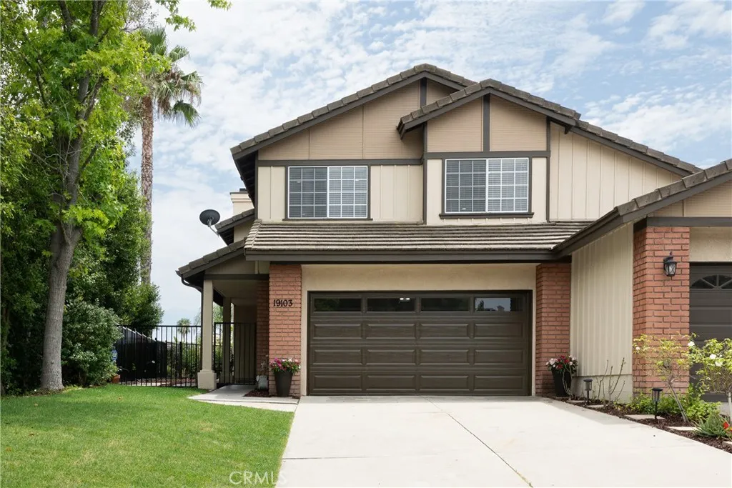 Th home has an attached two-car garage with direct access and an extended driveway for additional parking.