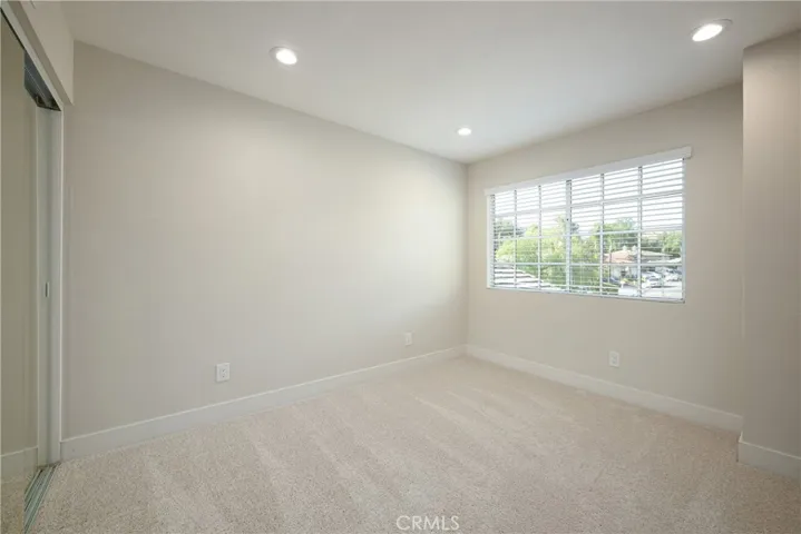 Additional guest bedroom with recessed lighting located upstairs.