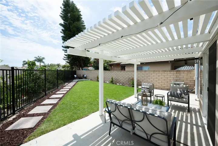 The large backyard and spacious side yard feature a covered patio, offering plenty of room for entertaining, relaxing, and outdoor dining.