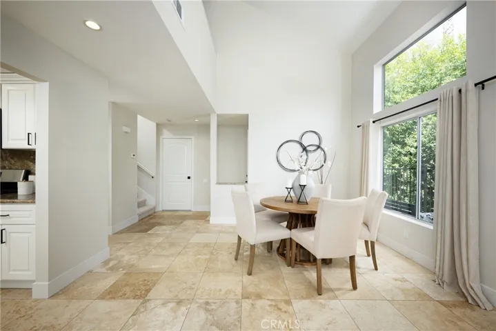 There is travertine flooring that flows seamlessly from the living room into the dining room.