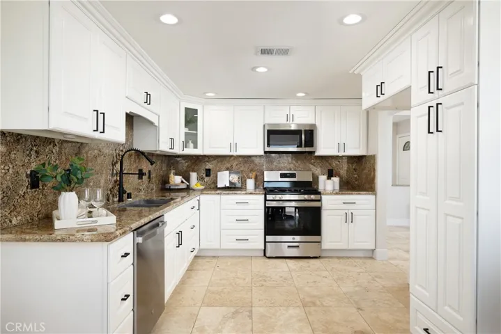 The kitchen offers white cabinetry and a new stainless steel oven and dishwasher.