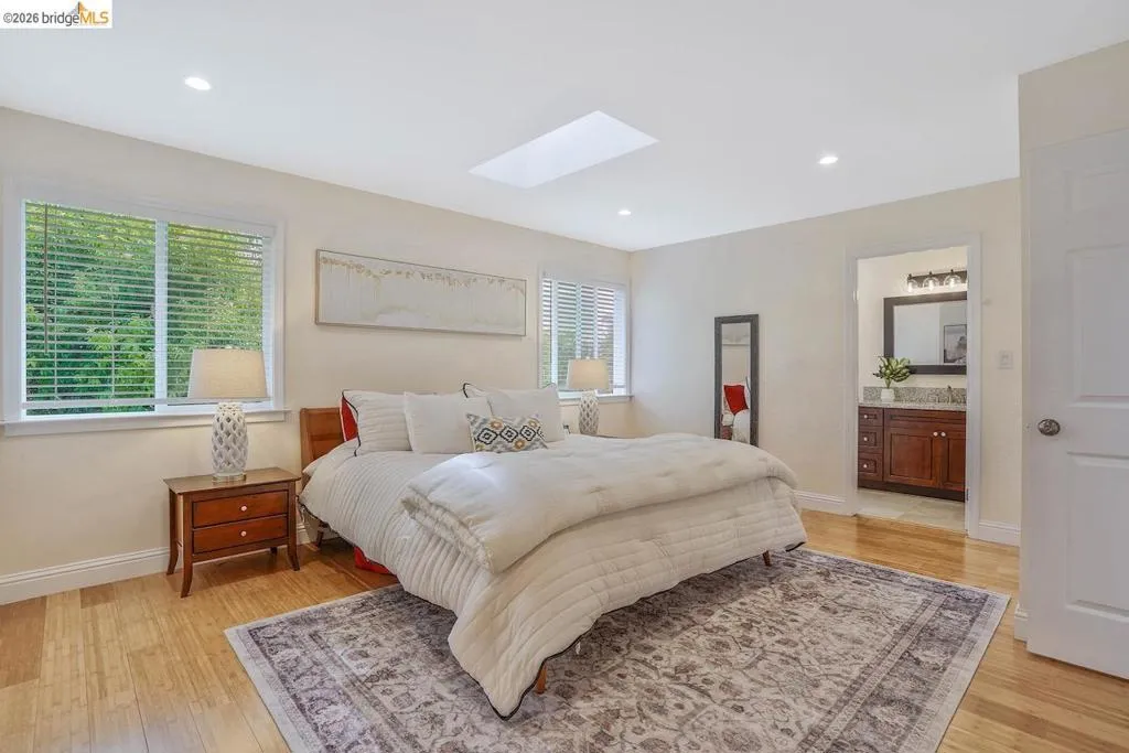Spacious room featuring wood-finish flooring, recessed lighting, and a skylight