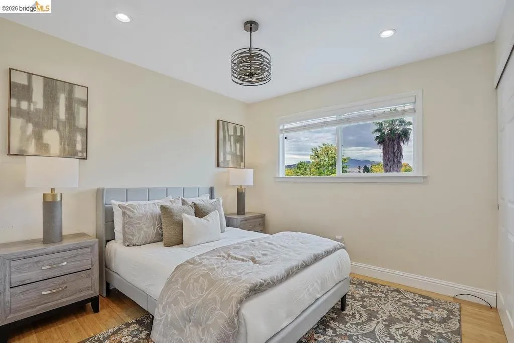 Bedroom featuring light wood-finish flooring, recessed lighting, and a modern chandelier