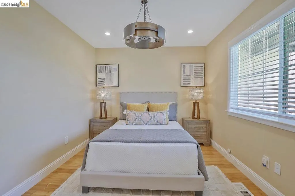 Bedroom featuring a recessed lighting, a ceiling fan with a circular metal fixture, and wood-finish flooring
