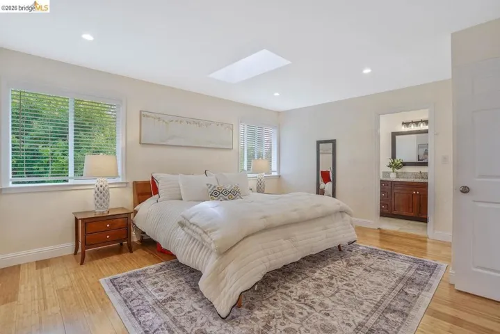 Spacious room featuring wood-finish flooring, recessed lighting, and a skylight