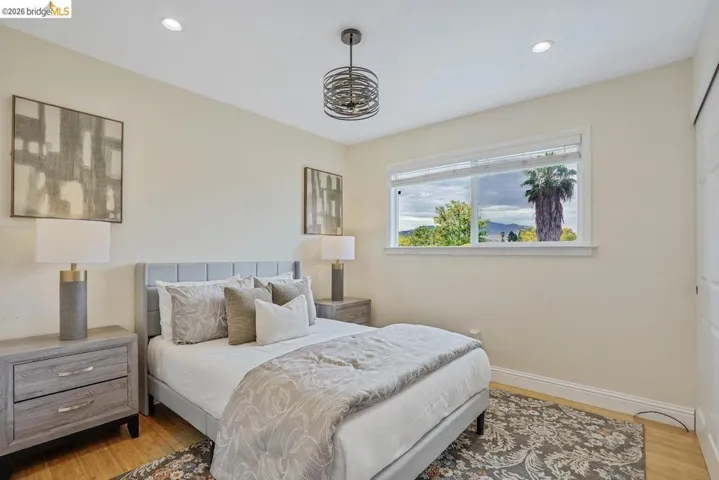 Bedroom featuring light wood-finish flooring, recessed lighting, and a modern chandelier