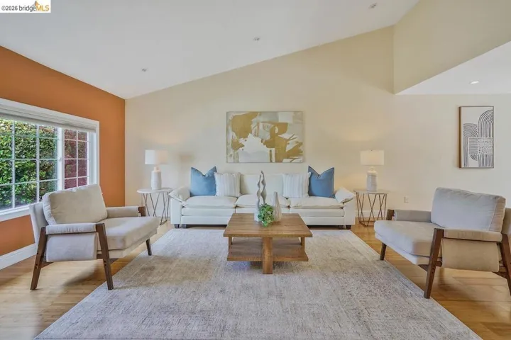 Living area featuring a vaulted ceiling and light wood-finish flooring