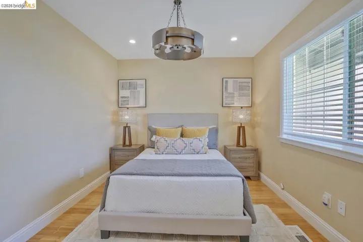 Bedroom featuring a recessed lighting, a ceiling fan with a circular metal fixture, and wood-finish flooring