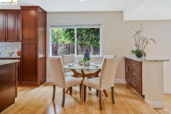 Kitchen featuring wood-finish flooring, a light-colored tile backsplash, dark wood cabinetry, and light-toned countertops