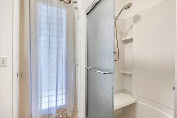 Shower with bench located in the Primary bathroom.