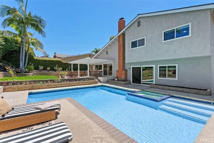 A spacious concrete patio surrounds the pool, providing plenty of space for sunbathing, entertaining, or simply relaxing in the California sun.