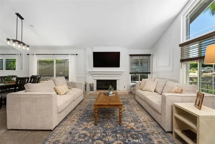 Perfect for hosting or relaxing, this light-filled living area offers a comfortable layout, elegant wall molding, and direct sliding door access to the outdoor patio.