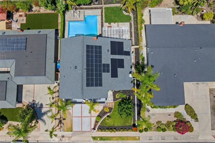 A straight-down aerial perspective highlights the generous lot size, showing the perfect layout of the home, pool, shaded patio, and green spaces.