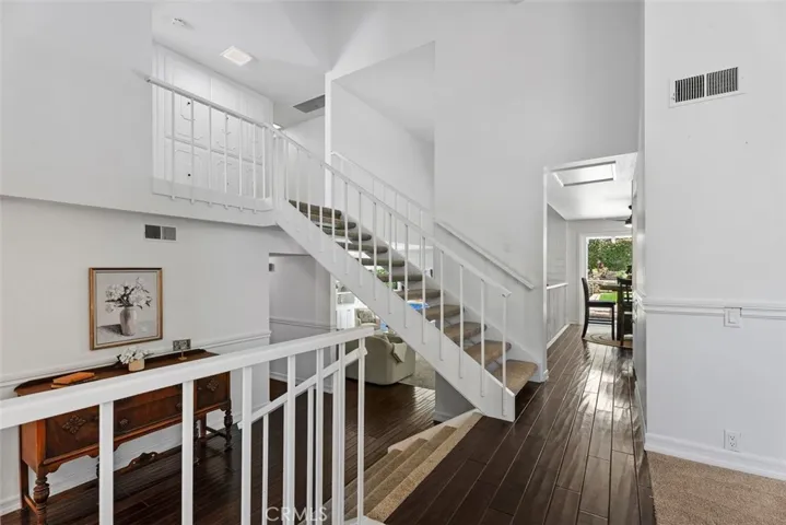 The home's dramatic split-level architecture is showcased by a central open-spindle staircase that connects the different living areas.