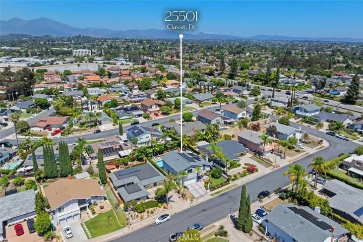 A spectacular bird's-eye view details the backyard layout, featuring the sparkling swimming pool, shaded patio dining, manicured lawn, and complete privacy landscaping.