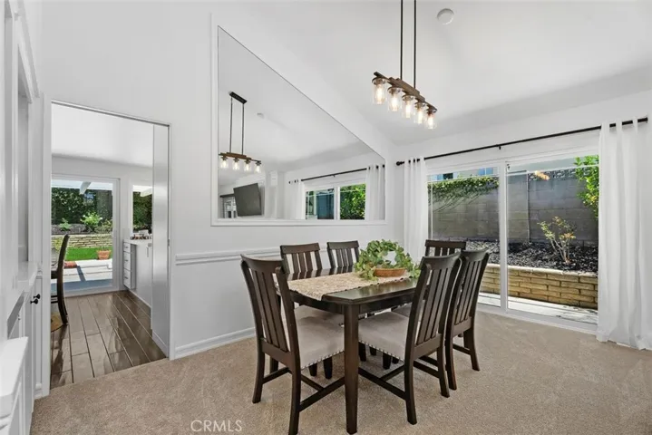 Double sliding doors lead directly to the side yard, seamlessly connecting this elegant, wainscot-paneled dining room with the outdoors.