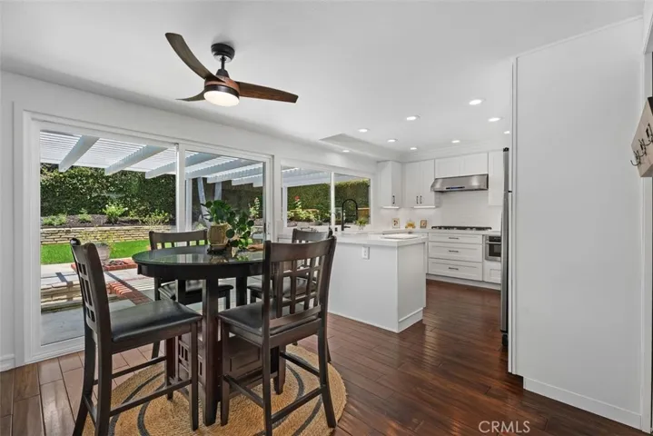 Perfect positioned between the kitchen and family room, this casual dining area features engineered hardwood flooring, a sleek modern ceiling fan, and sliding doors to the backyard patio.