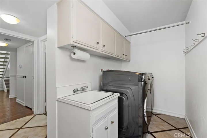 The dedicated laundry room offers ultimate convenience with a built-in utility sink and upper storage cabinets.