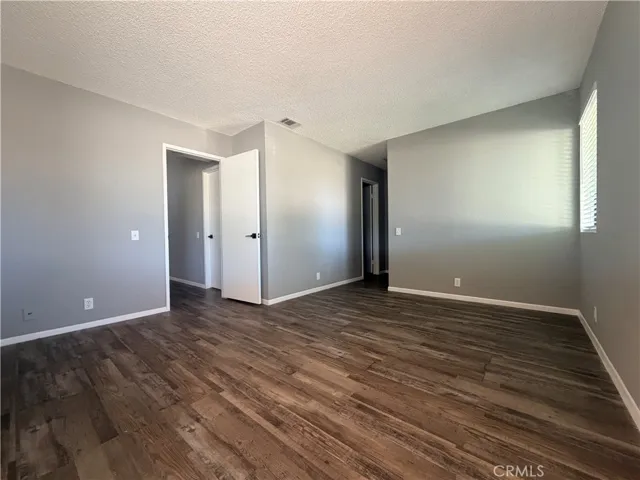 Primary bedroom showing hallway to closet and bathroom