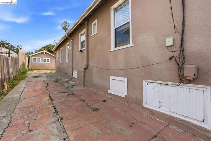 Side yard access with a paved pathway leading to a detached structure
