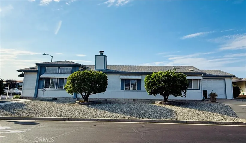 Side view of house showing two fruit trees and single car garage on right.