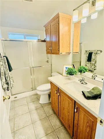 Guest bathroom located in hallway has tub and shower enclosure.