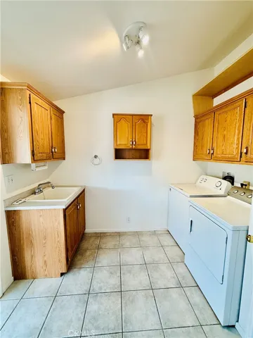 Laundry room is near the kitchen and has a side patio door.