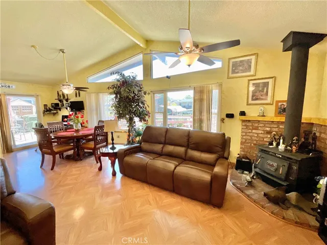 Living room shows high ceilings plus a fireplace and it is all open to dining area and kitchen with view of the canal waters of Clear Lake