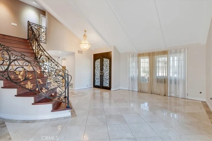 Another view of the entrance, custom spiral staircase, flooring and custom entrance door