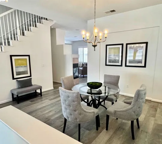 Dining area featuring wood-finish flooring and a contemporary chandelier