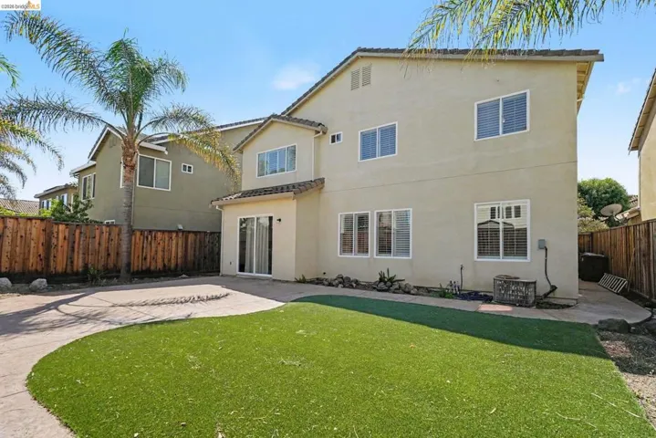 Rear exterior of a two-story residence featuring stucco siding and a tile roof
