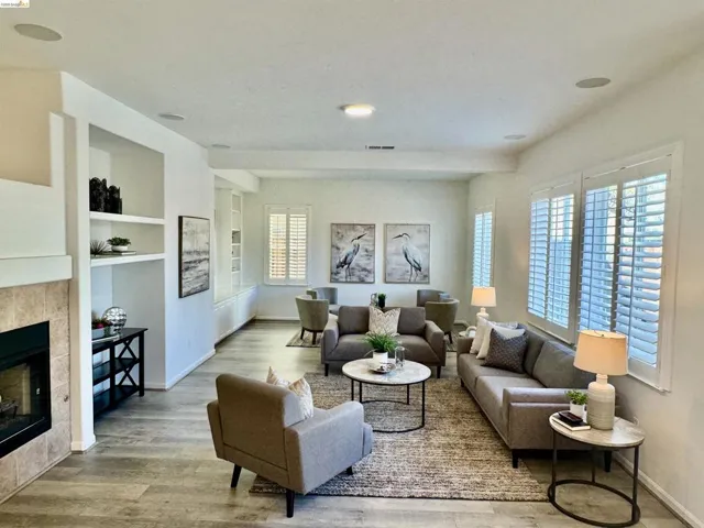 Spacious living area featuring wood-finish flooring, recessed lighting, and integrated ceiling speakers