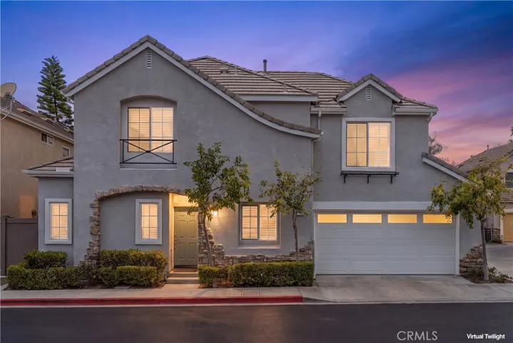 Stunning twilight exterior showcasing the home's charming architecture, stone accents, and welcoming front entry.