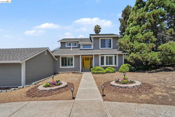 Two-story gray siding residence featuring a bright yellow front door