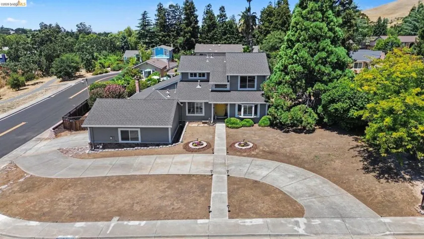 Two-story property featuring a gray exterior with white trim, a dark gray shingle roof, and a prominent yellow front door
