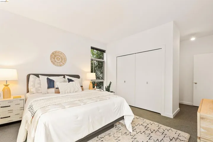 Bedroom featuring a window with exterior tree-line scenery, white walls, and a recessed ceiling light
