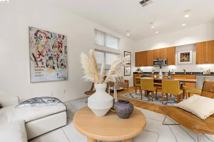 Open-concept living space featuring wood-finish flooring, recessed lighting, and high ceilings