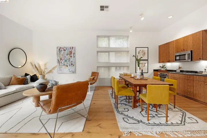 Open-concept living space with light wood-finish flooring, white walls, and recessed lighting
